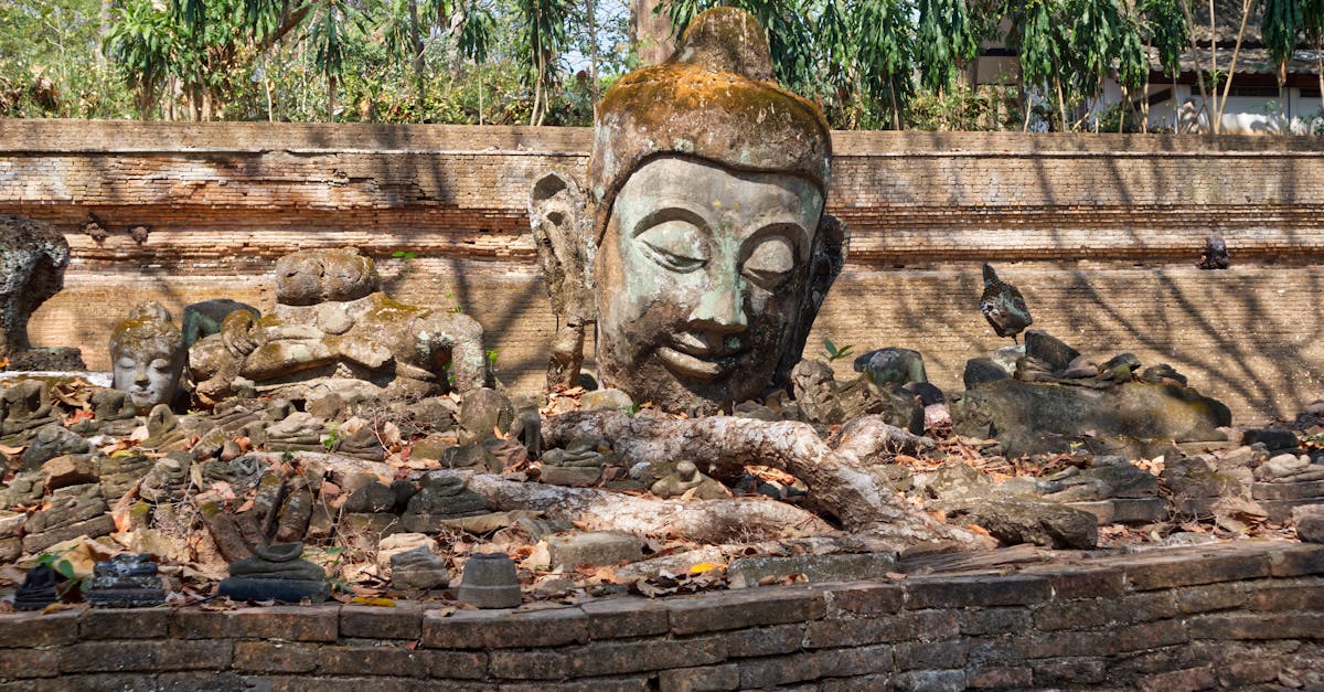 A serene Buddha head amidst ancient bricks and ruins in Chiang Mai, Thailand.