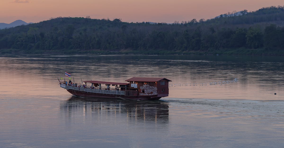 A tranquil evening view of a boat on the Mekong River at sunset in Chiang Khan, Thailand.
