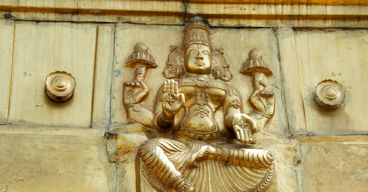 Golden carving depicting a deity from Hindu mythology on a temple wall.