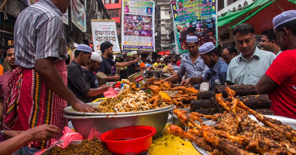 Local vendors in Dhaka's street market selling diverse fried street foods, attracting a crowd.