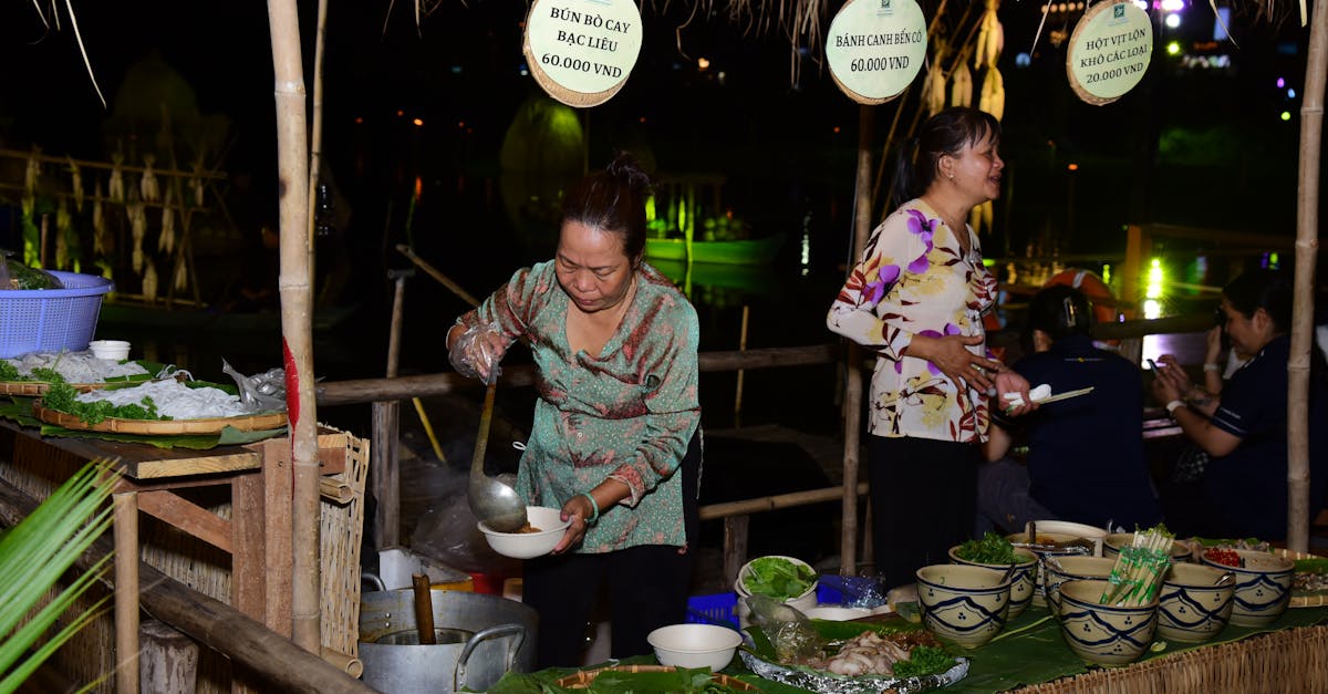 Vendor serving traditional Vietnamese dishes at a bustling night market.