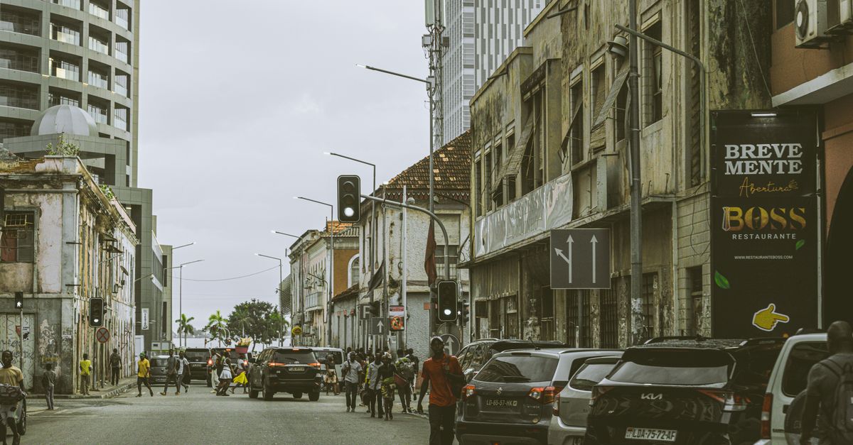 Bustling street scene in downtown Luanda, Angola with historic and modern buildings.