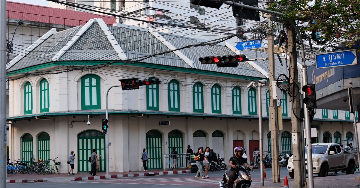 A bustling intersection in Bangkok featuring colonial architecture and vibrant street life.