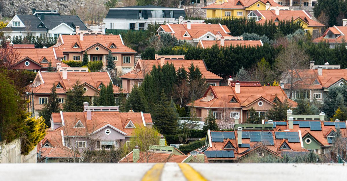 Scenic view of suburban houses with red roofs in Ankara, Türkiye, surrounded by lush greenery and hills.
