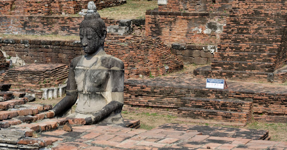 Ruins of Wat Mahathat with an ancient Buddha statue in Ayutthaya, Thailand.