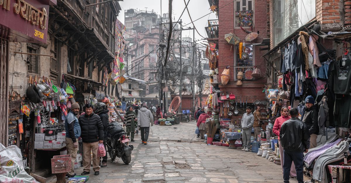 Street view of a lively market in Kathmandu, Nepal with vendors and shoppers.