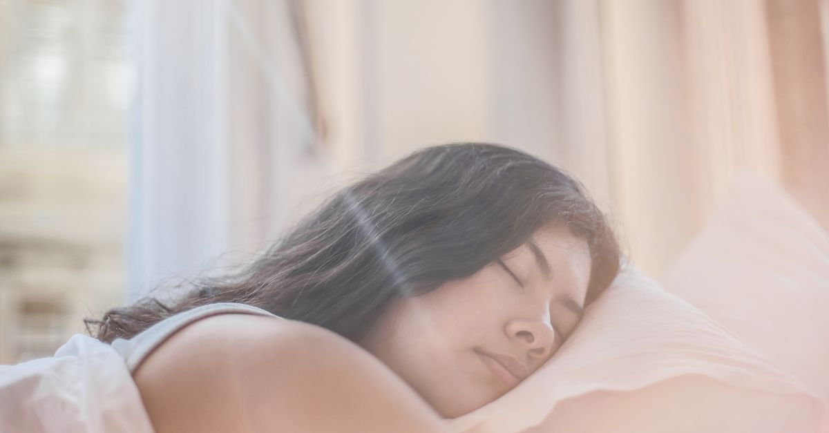 Portrait of a woman sleeping peacefully in soft morning light indoors.