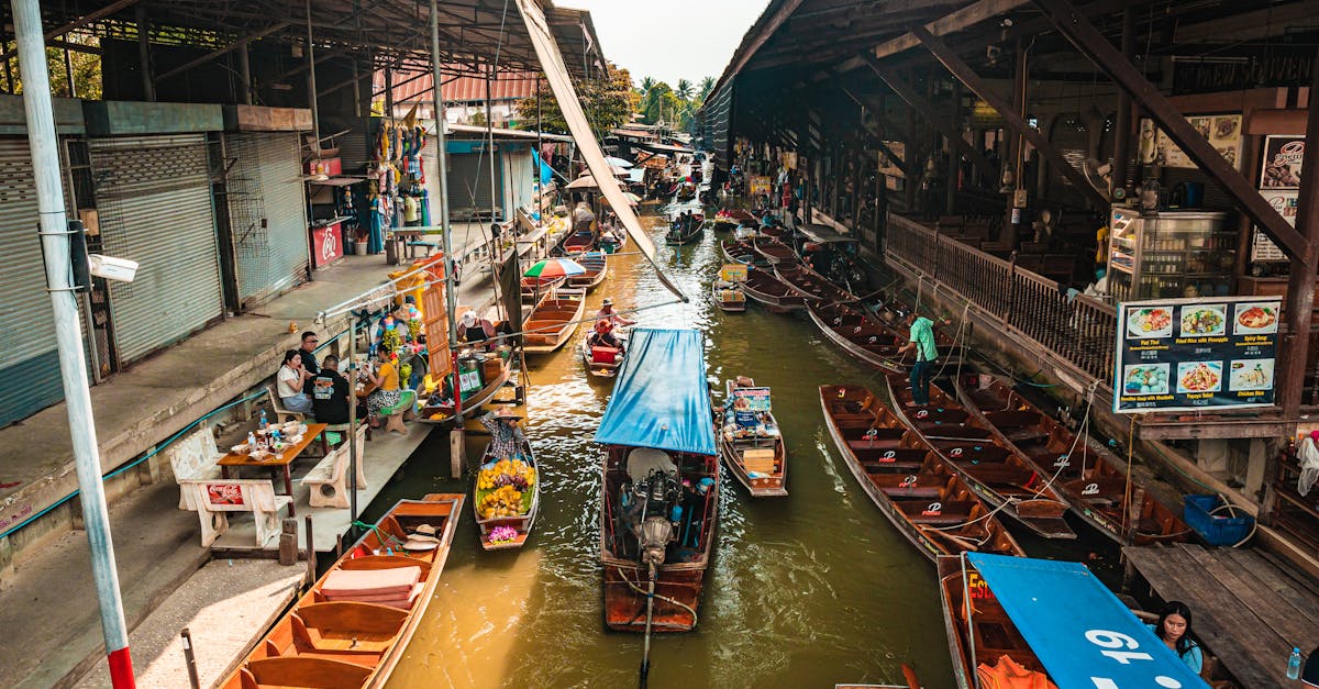 Bustling floating market in Bangkok with colorful boats and traditional vendors along the canal.