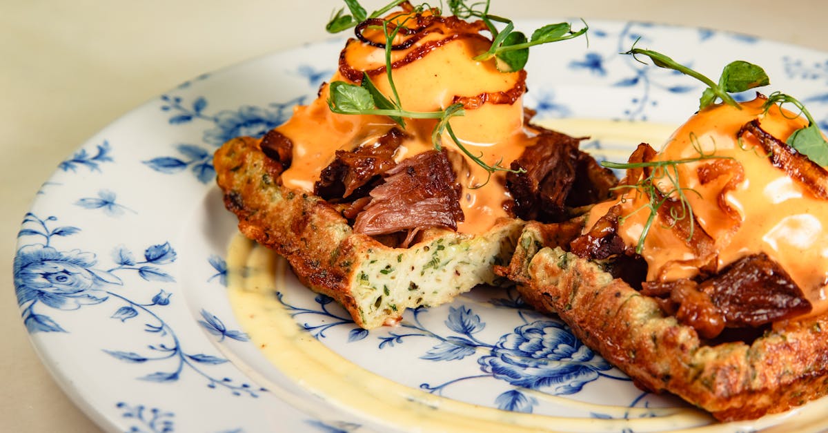 Mouthwatering waffle served on a floral ceramic plate with savory toppings.