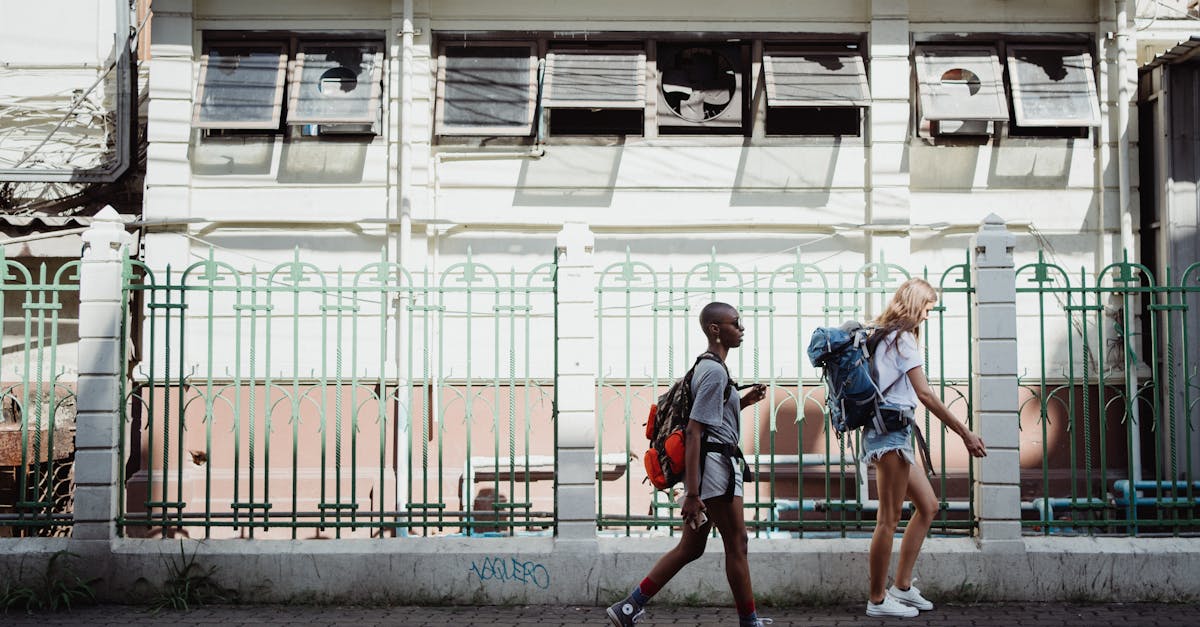 Two women walking with backpacks on a city sidewalk, embracing urban exploration.
