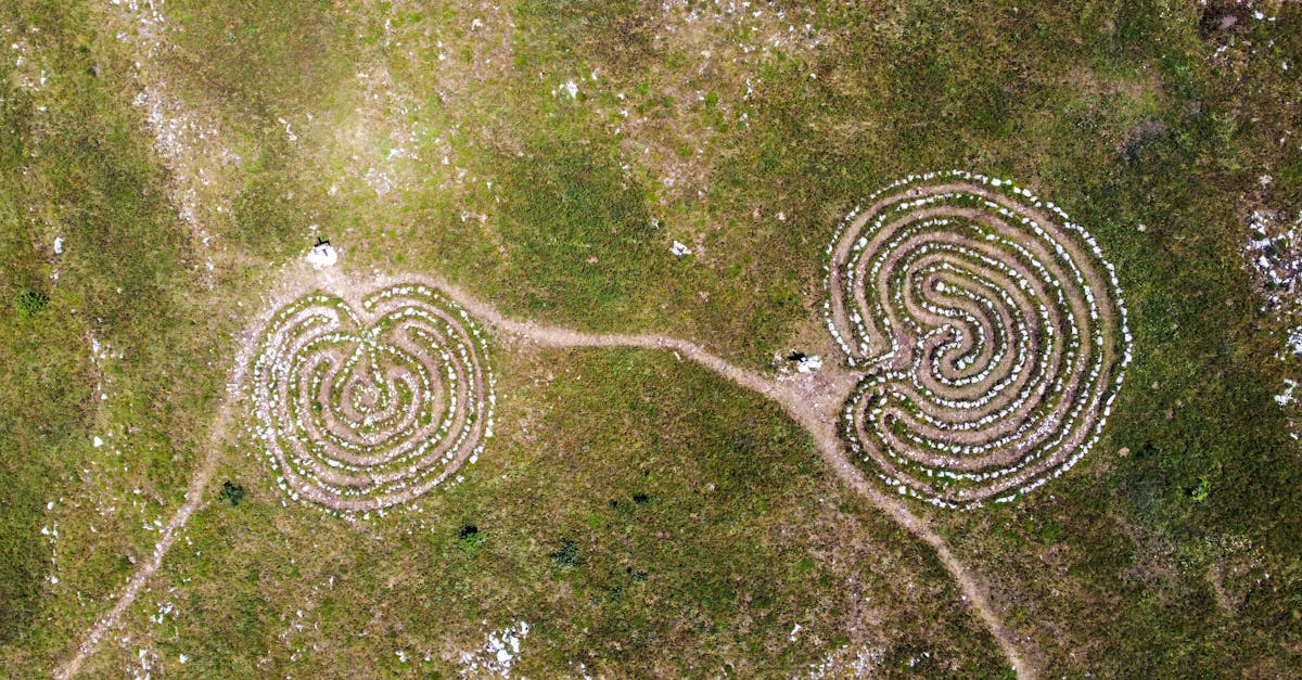 Two spiral stone labyrinths on a grassy field captured from above.