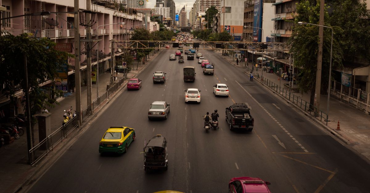 Aerial view of traffic on a bustling urban highway surrounded by city buildings.