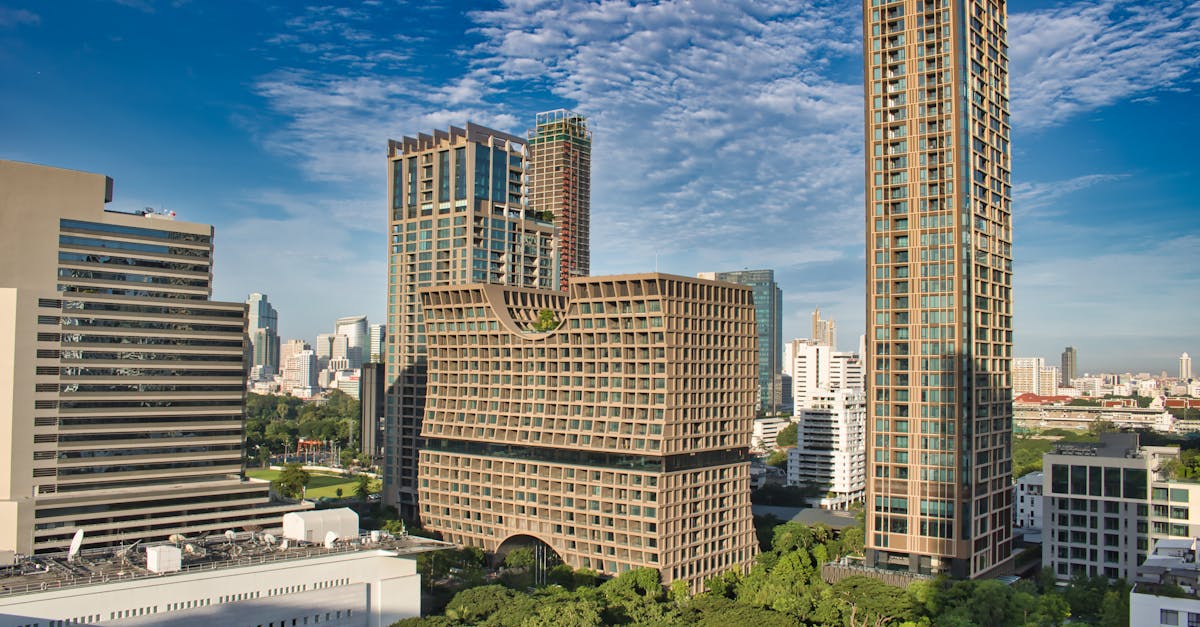 Vibrant view of Bangkok skyline featuring modern architecture and lush greenery under a clear blue sky.