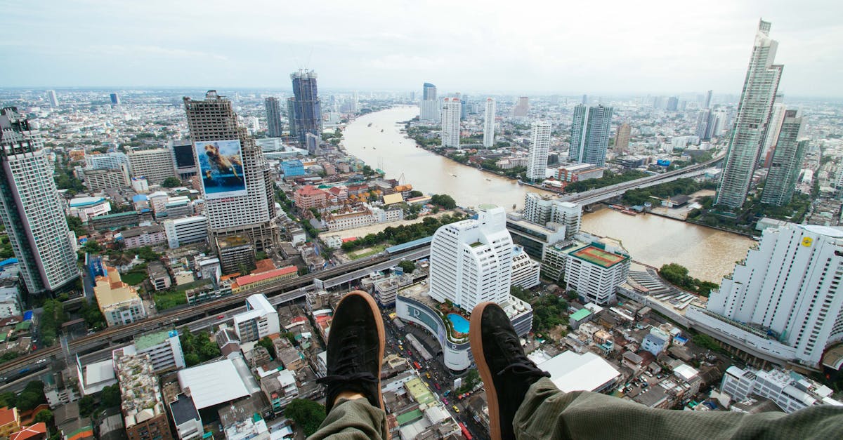 A thrilling cityscape of Bangkok with a bird's-eye view over the river and shoes in the foreground.