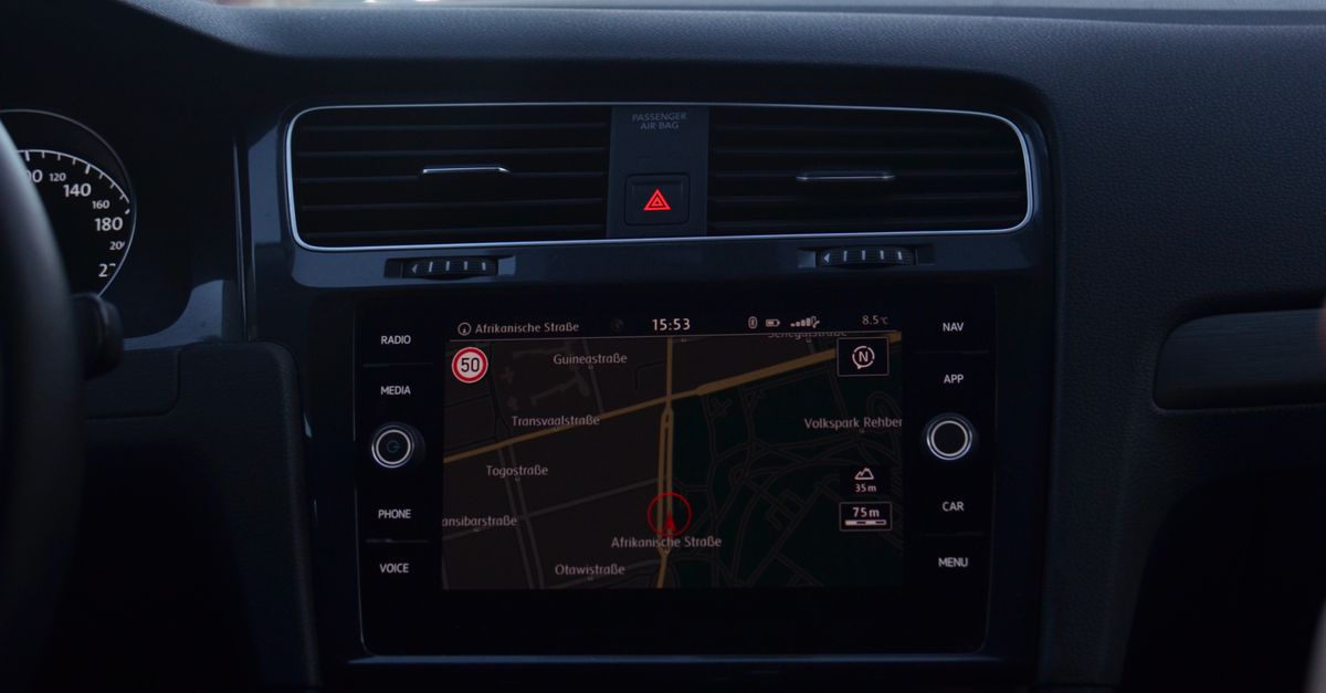 Interior of modern car with steering wheel and navigation system showing route through city streets