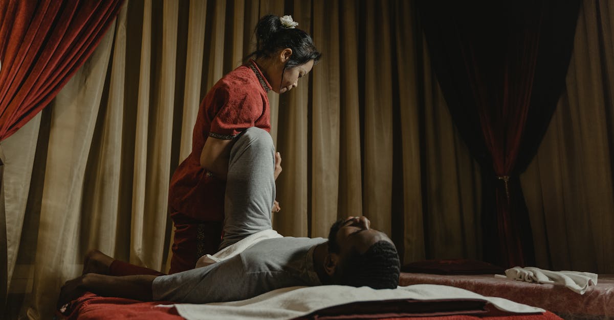Therapist performing a leg stretch on client in a serene spa setting, promoting relaxation and wellness.