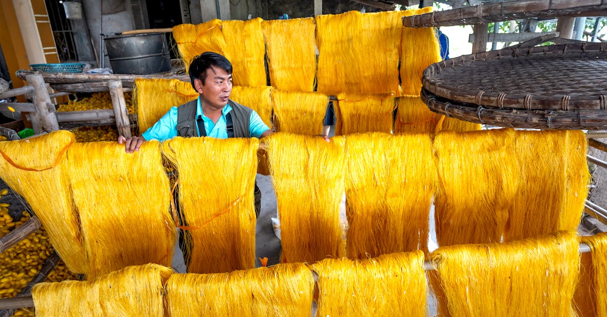 Worker with dyed silk strands in a traditional manufacturing setting.