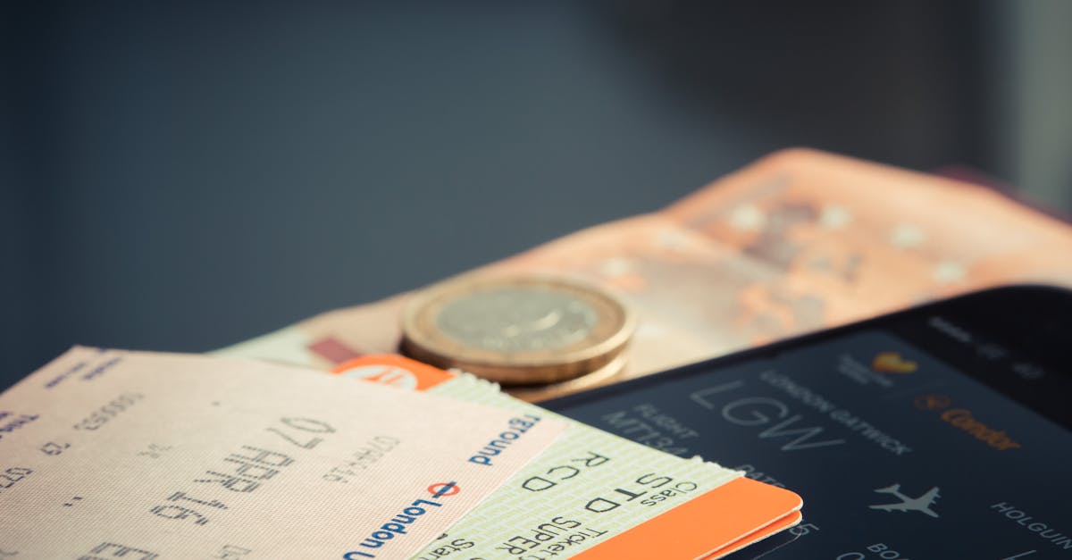 Airline ticket with euro coins and smartphone displaying flight details.
