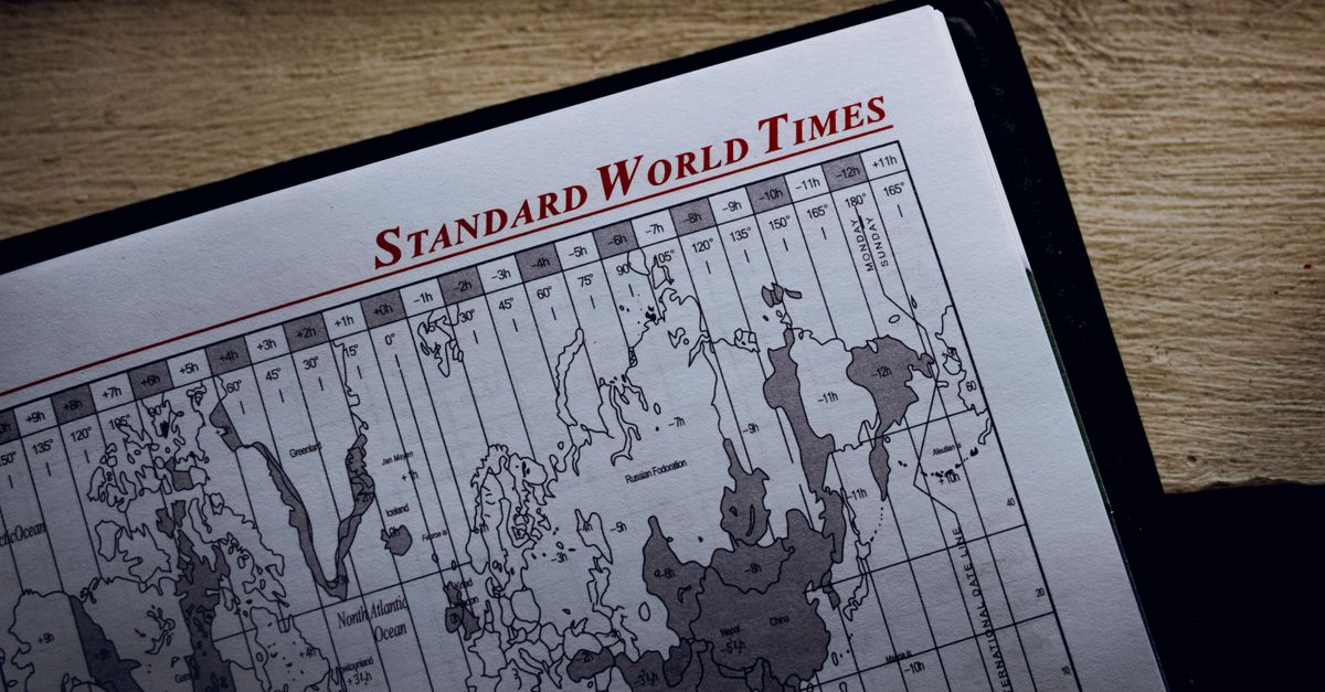 Top view of time zone illustration on page of agenda with inscription on wooden surface