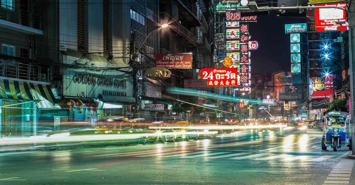 Dynamic night scene with traffic and neon lights on the bustling streets of Bangkok.