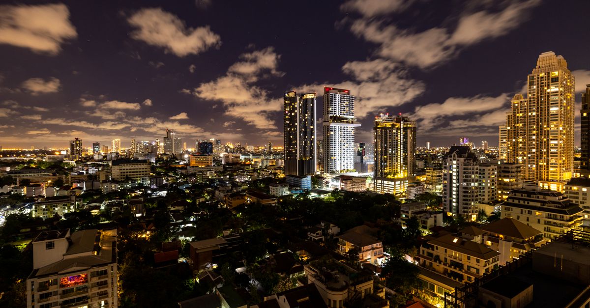 Mesmerizing view of Bangkok's illuminated skyline at night, showcasing modern skyscrapers.