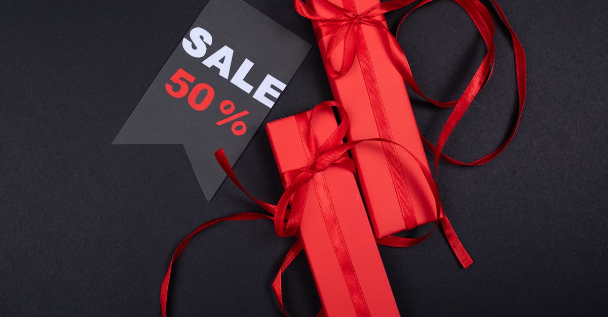 Red gift boxes with ribbons and a prominent 50% sale sign on black background.