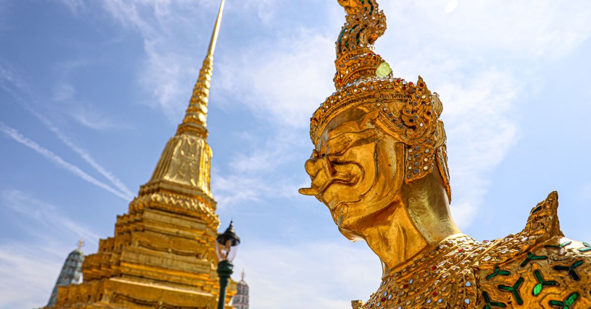 Stunning gold statue and pagoda at a Buddhist temple in Bangkok, Thailand.