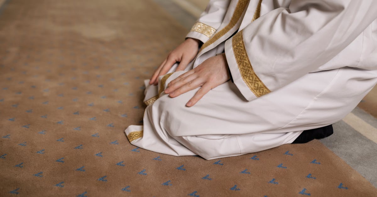 A man kneeling in prayer, wearing a traditional thawb during a religious moment.