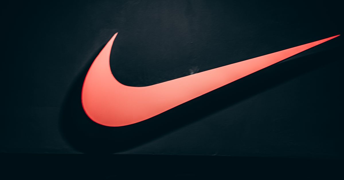 Vibrant red Nike swoosh logo displayed on a dark, minimalist backdrop symbolizing sports and lifestyle.