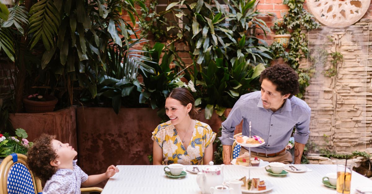 Family dining outdoors, surrounded by lush greenery and enjoying quality time together.