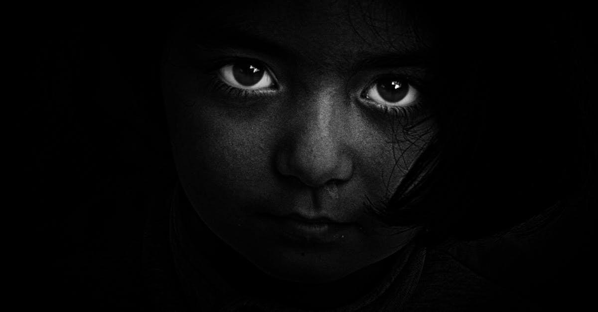 Intense black and white portrait of a child with captivating eyes, evoking mystery and emotion.