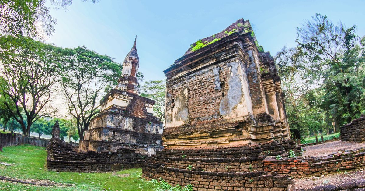 Explore ancient Buddhist ruins in a serene park setting, capturing historic Thai architecture.